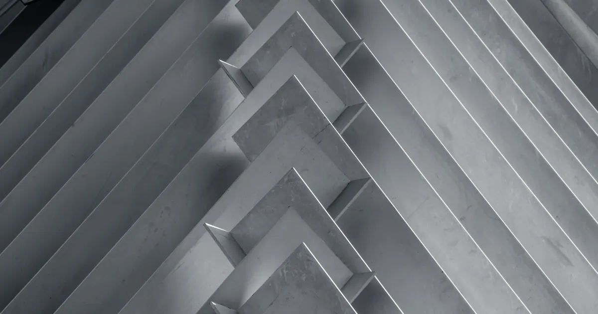 Stacked grey metal profile sections, stock of the kind bought for 5 axis aluminum machining in Vietnam
